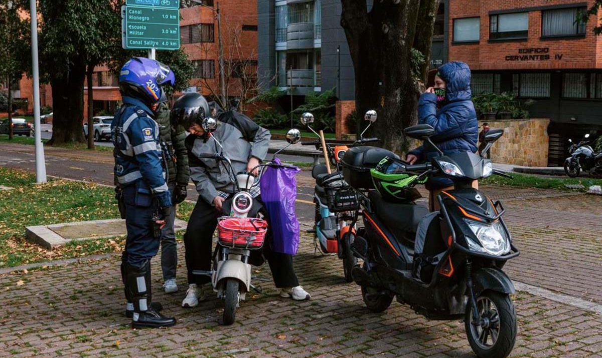 Motos eléctricas tipo moped circulando por ciclorruta en Bogotá tras Ley 2486