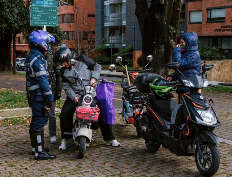 Motos eléctricas tipo moped circulando por ciclorruta en Bogotá tras Ley 2486