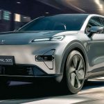 Vista frontal en movimiento del crossover híbrido y eléctrico Deepal S05 plateado circulando por una calle urbana moderna, destacando su diseño aerodinámico.