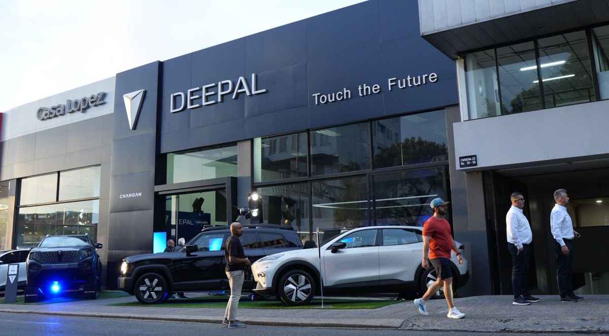 Vista exterior aérea del nuevo concesionario automotriz de Changan y Deepal en Manizales, operado por Casa López. En la entrada se exhiben varios vehículos híbridos y eléctricos de las marcas, incluyendo la pick-up Hunter y el SUV G318, con personas alrededor durante la inauguración.