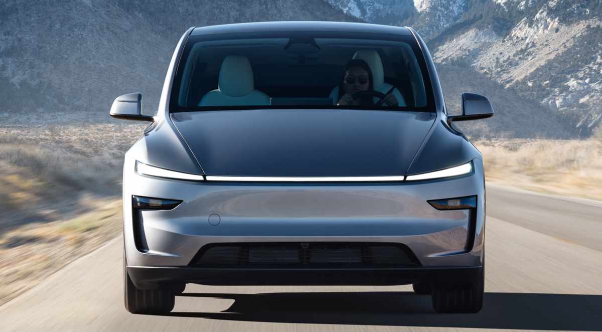 Primer plano frontal de un Tesla Model Y plateado en movimiento sobre una carretera rural con montañas desérticas al fondo, representando el éxito de ventas de la marca en Colombia durante marzo.