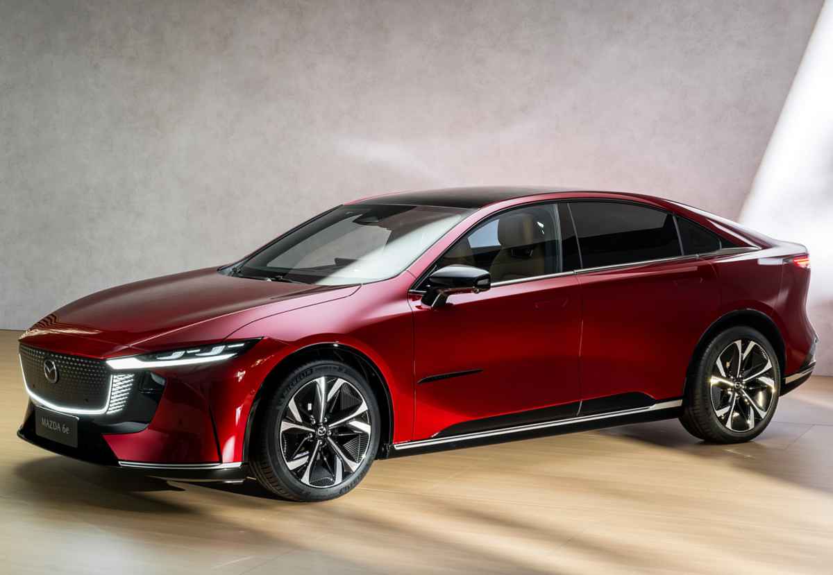 Elegante perfil del sedán Mazda 6e (EZ-6) en color rojo, exhibiendo el tradicional diseño Kodo que le otorgó el reconocimiento al Mejor Diseño del Año 2026.