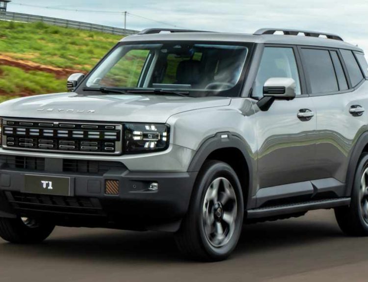 Vista frontal de tres cuartos de la nueva SUV híbrida Jetour T1 i-DM circulando por una carretera, resaltando su diseño cuadrado y rudo.