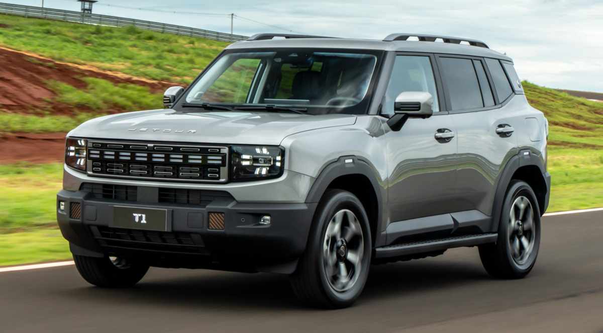 Vista frontal de tres cuartos de la nueva SUV híbrida Jetour T1 i-DM circulando por una carretera, resaltando su diseño cuadrado y rudo.