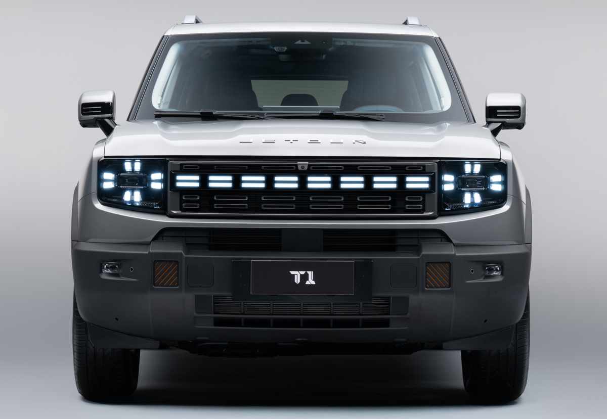 Plano frontal total de la camioneta Jetour T1 i-DM con las luces LED encendidas en forma de cruz, destacando la parrilla rectangular y su aspecto robusto.