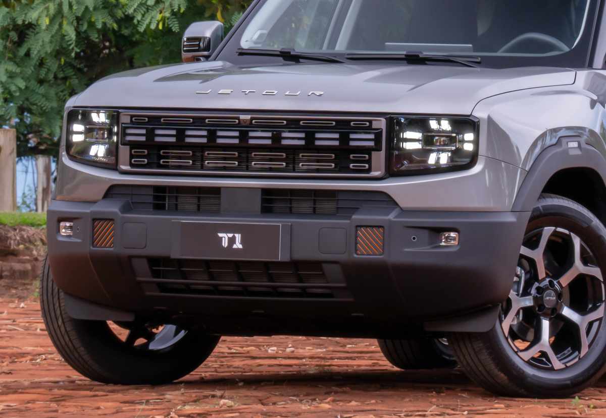 Detalle frontal en primer plano de la Jetour T1 i-DM enfocando la parrilla iluminada, las luces diurnas LED cuadradas y la placa con el nombre 'T1'.