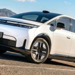 Vista frontal de la nueva minivan eléctrica GAC Aion N60 circulando en carretera, luciendo su color Blanco Polar y demostrando su diseño de gran eficiencia aerodinámica.