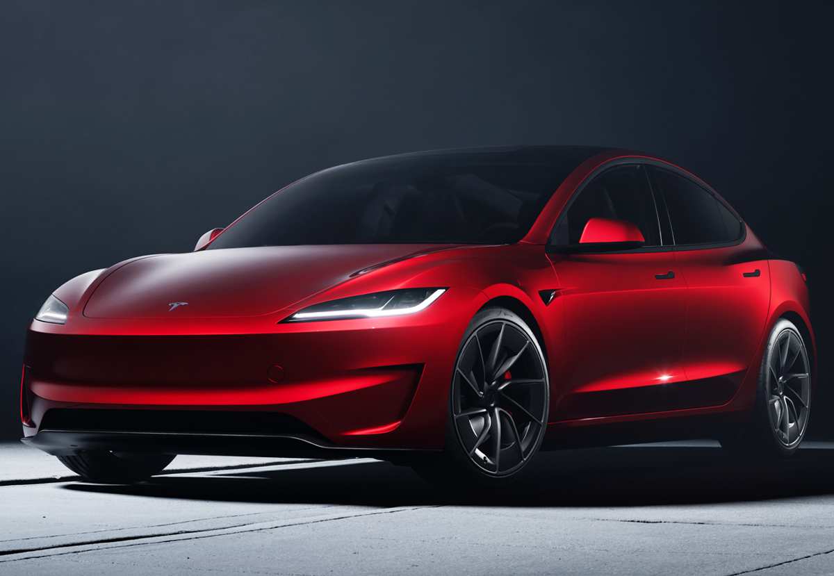 Un Tesla Model 3 actualizado (Highland) color rojo, se muestra en un plano frontal dinámico en un estudio oscuro, destacando las nuevas luces LED diurnas en forma de tira y las líneas más afiladas.