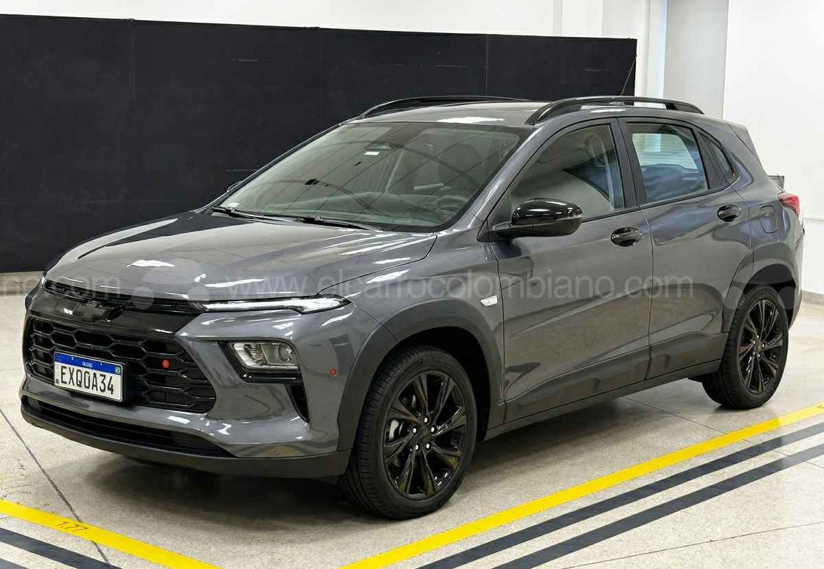 Una recreación detallada generada por IA (Gemini) del aspecto definitivo del nuevo crossover Chevrolet Sonic en gris oscuro, con rines y parrilla negros, en un estudio de diseño con marcas de piso amarillas. Exclusiva de EL CARRO COLOMBIANO.