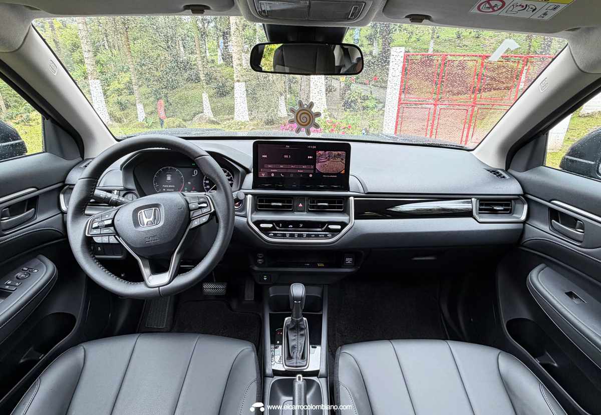 Vista interior completa del tablero de la Honda WR-V en Colombia, mostrando el volante multifunción, el panel de instrumentos y la pantalla multimedia central.