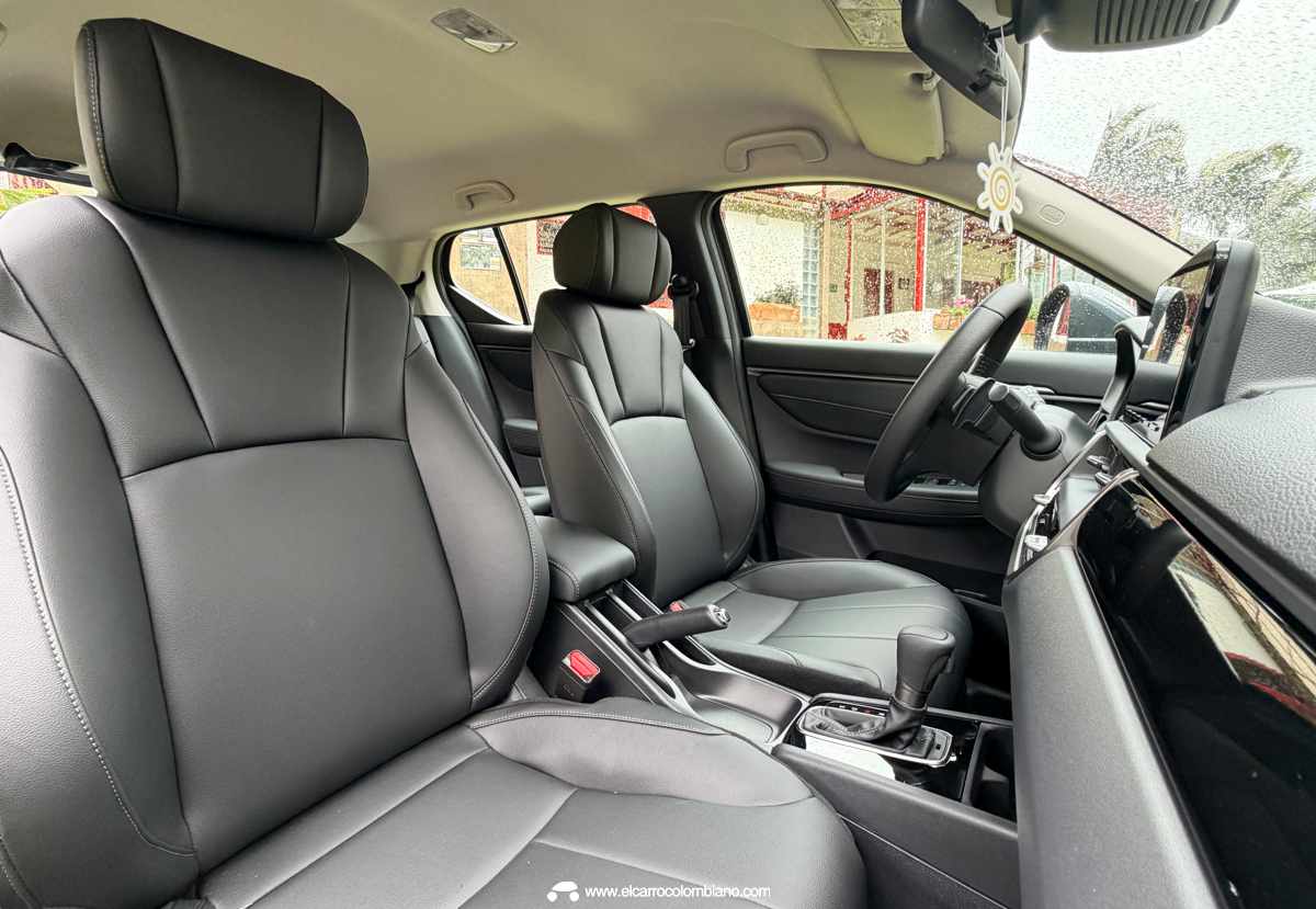 Vista del habitáculo interior de la Honda WR-V con asientos delanteros en cuero sintético gris, consola central con palanca de cambios y vista del tablero.