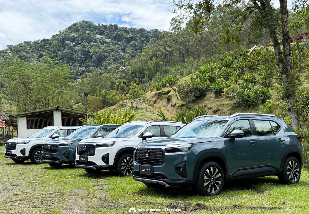 Una flota de cuatro SUV Honda WR-V gris oscuras alineadas sobre césped en un paisaje montañoso colombiano durante un evento de prueba, luciendo placas temporales.