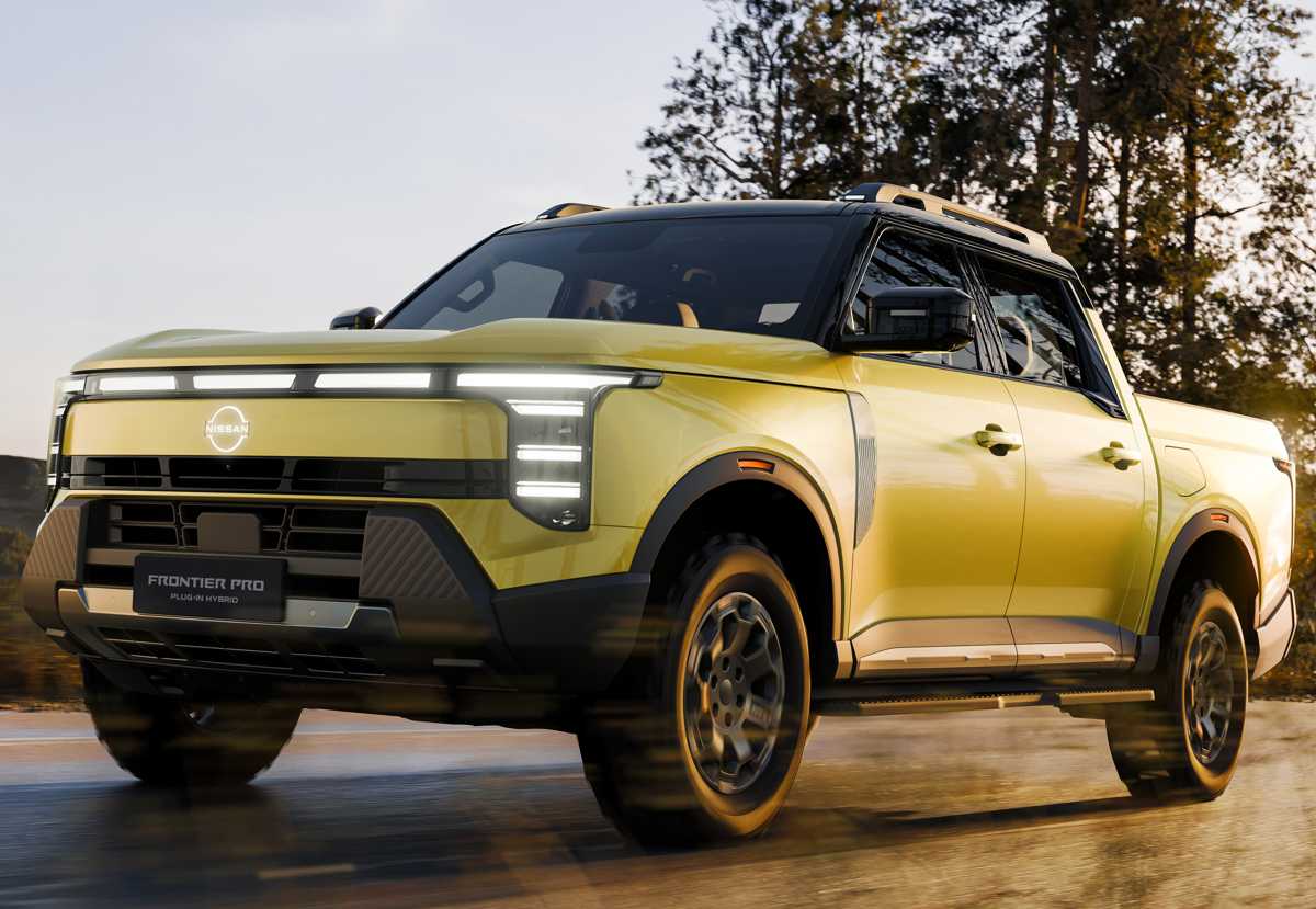 Vista de tres cuartos delantera de la nueva pick-up Nissan Frontier Pro Plug-in Hybrid color amarillo arena, en movimiento sobre una carretera rodeada de árboles.