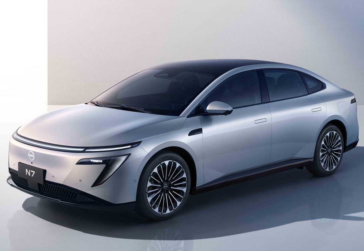 Vista frontal de tres cuartos del sedán eléctrico Nissan N7 color plata escarchado, exhibiendo su diseño aerodinámico fluido y su firma lumínica LED frontal en un estudio minimalista.