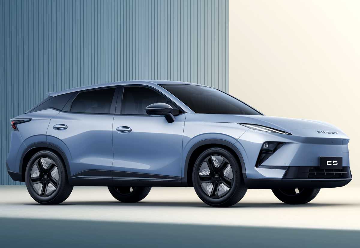 Perfil lateral completo de la Chery E5 eléctrica en color azul claro. Se aprecia su silueta tipo coupé con una suave caída de techo fastback, el efecto de techo flotante en el paral C, manijas de puertas enrasadas y líneas de estilo rectas sobre los guardafangos.