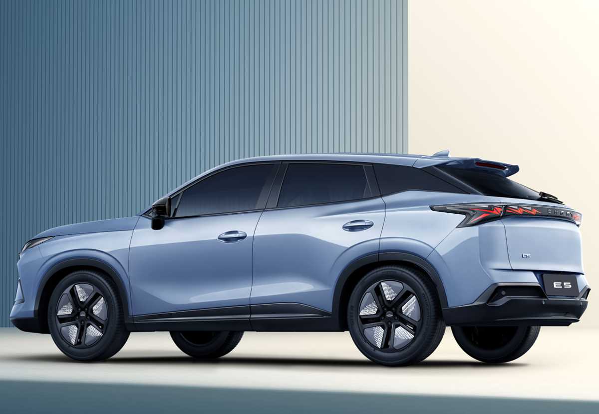 Vista de tres cuartos trasera de la nueva Chery E5 eléctrica color azul claro. Muestra el diseño posterior con la caída de techo coupé, las luces traseras LED interconectadas que forman una 