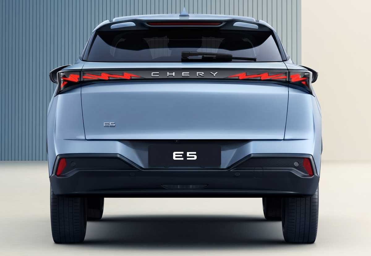 Vista trasera directa de la nueva SUV compacta eléctrica Chery E5. Destaca la barra de luces LED continuas con la forma de 'Z' estilizada y el nombre 'CHERY' integrado en el centro. El emblema 'E5' está en el portón trasero. El parachoques trasero tiene una sección inferior negra.
