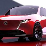 Vista frontal de estudio del concept car Mazda Vision X-Compact, un prototipo bicolor rojo y blanco con diseño Kodo evolucionado. Muestra faros LED delgados integrados en una moldura que forma una 'V' alrededor del emblema de la marca, rines oscuros de gran tamaño y una postura baja y ancha. Esta imagen anticipa el futuro diseño de los próximos Mazda 2 y CX-3.