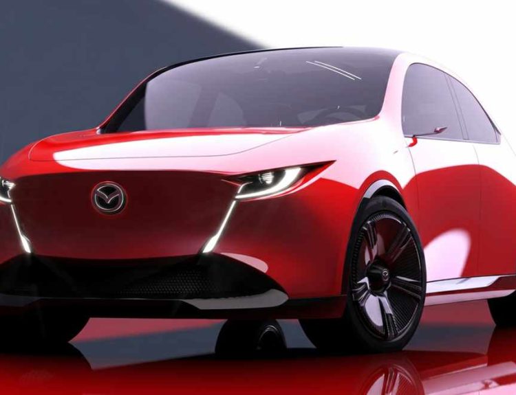 Vista frontal de estudio del concept car Mazda Vision X-Compact, un prototipo bicolor rojo y blanco con diseño Kodo evolucionado. Muestra faros LED delgados integrados en una moldura que forma una 'V' alrededor del emblema de la marca, rines oscuros de gran tamaño y una postura baja y ancha. Esta imagen anticipa el futuro diseño de los próximos Mazda 2 y CX-3.