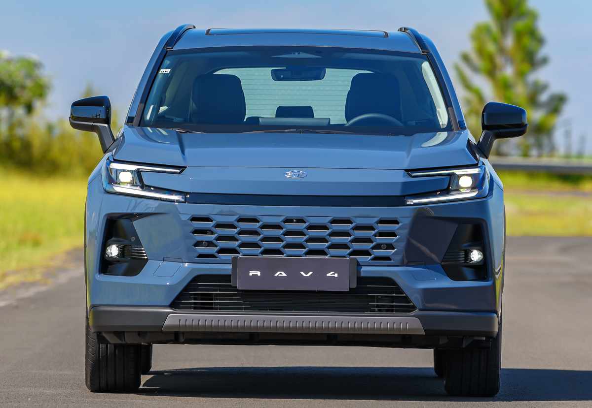 Vista frontal directa de la nueva Toyota RAV4 en color azul, resaltando la entrada de aire inferior tipo panal, las luces en forma de C y el emblema de Toyota en el centro.