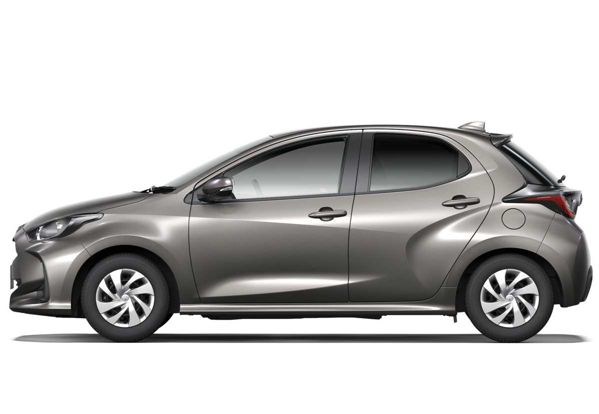 Perfil lateral completo de un Toyota Yaris híbrido en color beige metalizado (oro champagne) sobre un fondo gris, mostrando su forma de hatchback y líneas de diseño.