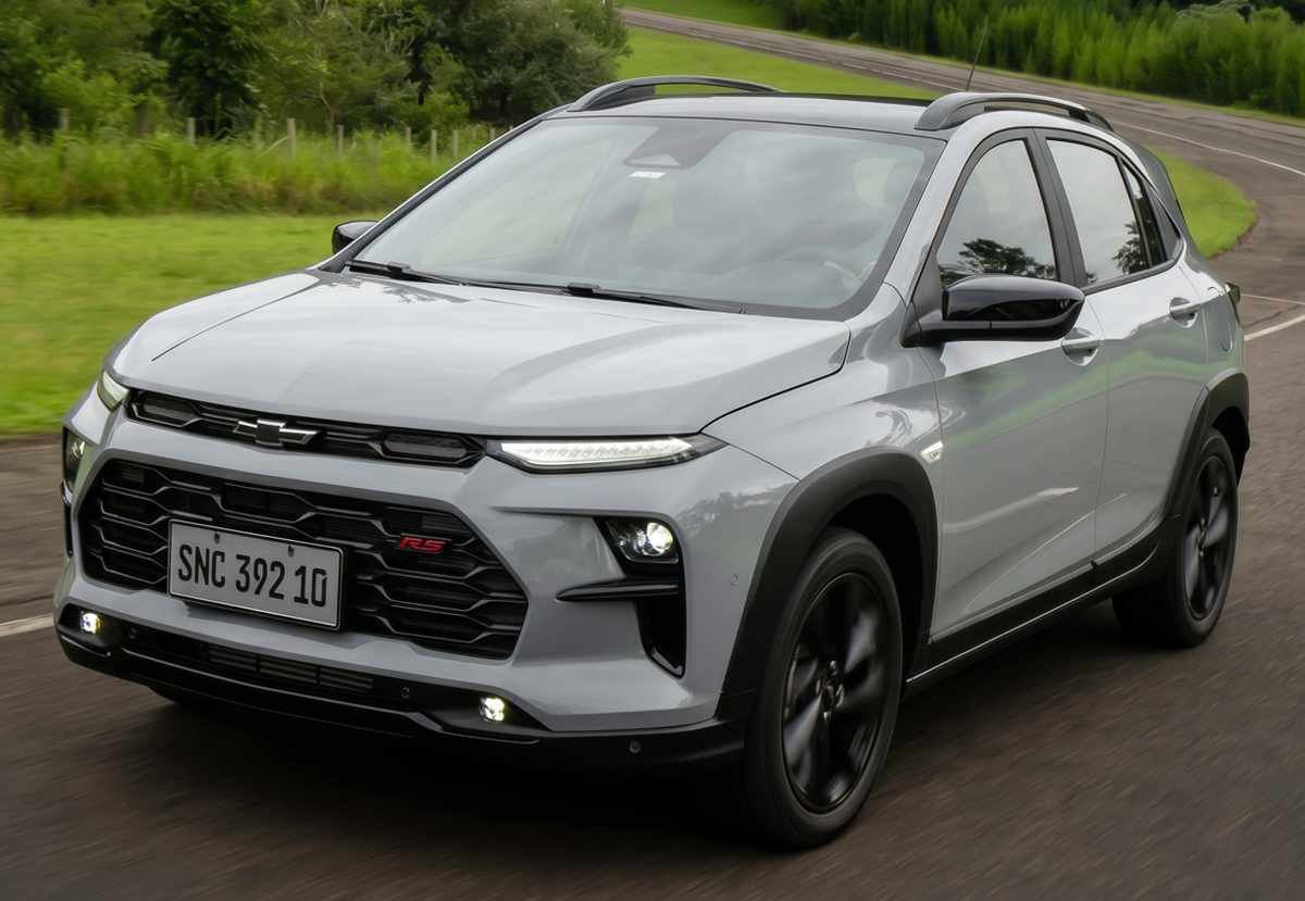 Vista tres cuartos delantera del Chevrolet Sonic 2027 plateado en movimiento sobre asfalto, detallando sus faros LED de proyección, luces diurnas superiores, parrilla con emblema 