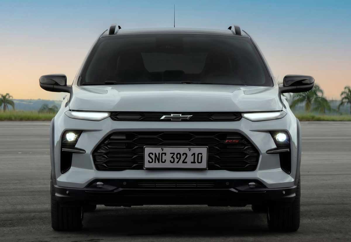 Vista frontal directa del Chevrolet Sonic 2027 plateado, destacando su agresivo diseño dividido con luces diurnas afiladas arriba, faros principales abajo, la gran parrilla con el emblema 