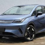 Vista tres cuartos delantera del nuevo BYD Dolphin 2026 color azul estacionado en exteriores, mostrando su renovado diseño frontal, faros LED y rines bitono aerodinámicos.