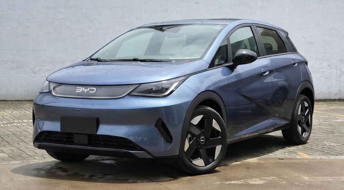 Vista tres cuartos delantera del nuevo BYD Dolphin 2026 color azul estacionado en exteriores, mostrando su renovado diseño frontal, faros LED y rines bitono aerodinámicos.