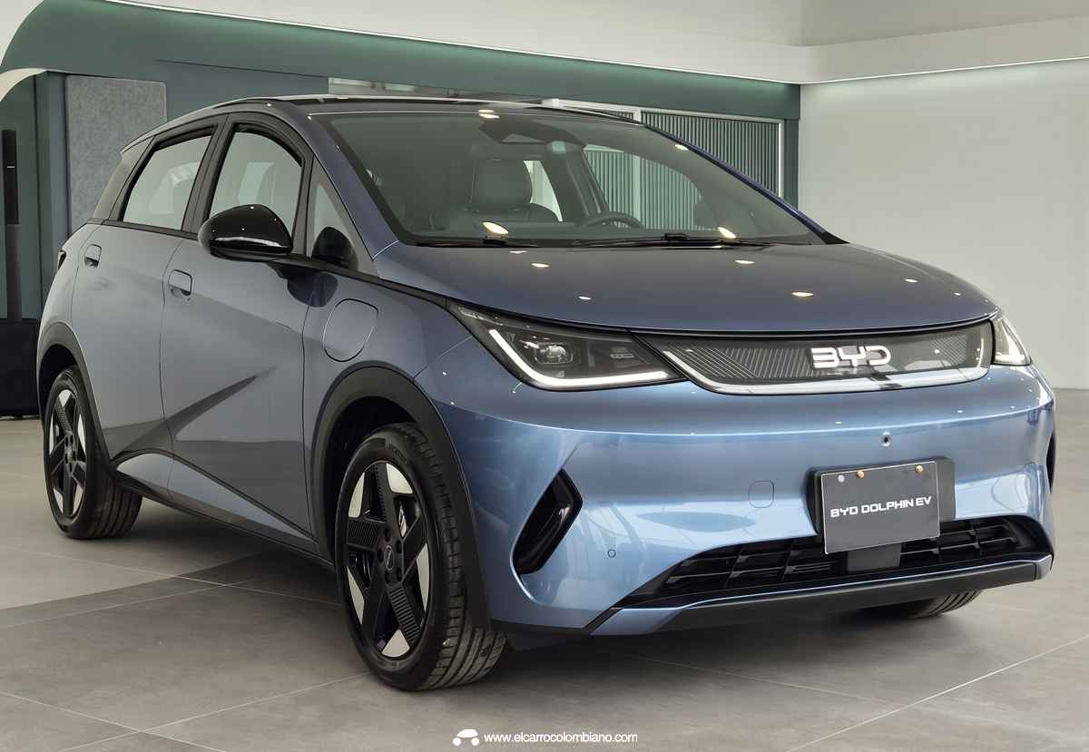 Vista tres cuartos delantera del nuevo BYD Dolphin 2026 en vitrina comercial, destacando el diseño afilado de sus faros LED y su nuevo bumper delantero con ductos aerodinámicos laterales.
