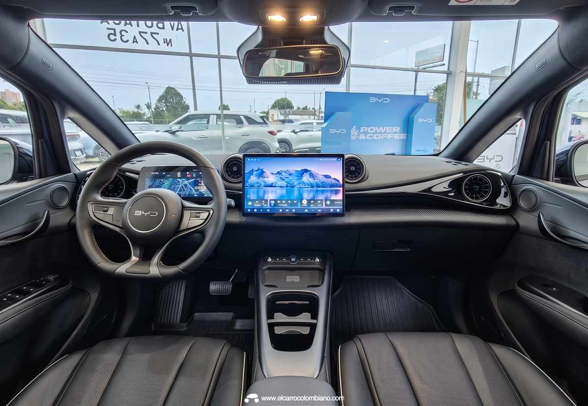 Vista panorámica del diseño interior y tablero del nuevo BYD Dolphin 2026, revelando el volante multifunción, el panel digital y la gran pantalla táctil central de 12,9 pulgadas.