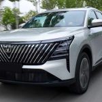 Vista tres cuartos delantera de la nueva Changan CS75 Plus HEV plateada en movimiento sobre una avenida, destacando su enorme parrilla frontal con barras inclinadas.