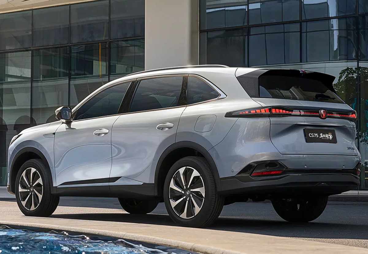 Vista tres cuartos trasera de la Changan CS75 Plus HEV plateada estacionada, detallando su firma lumínica LED horizontal, el spoiler trasero y la nueva estética de la compuerta.