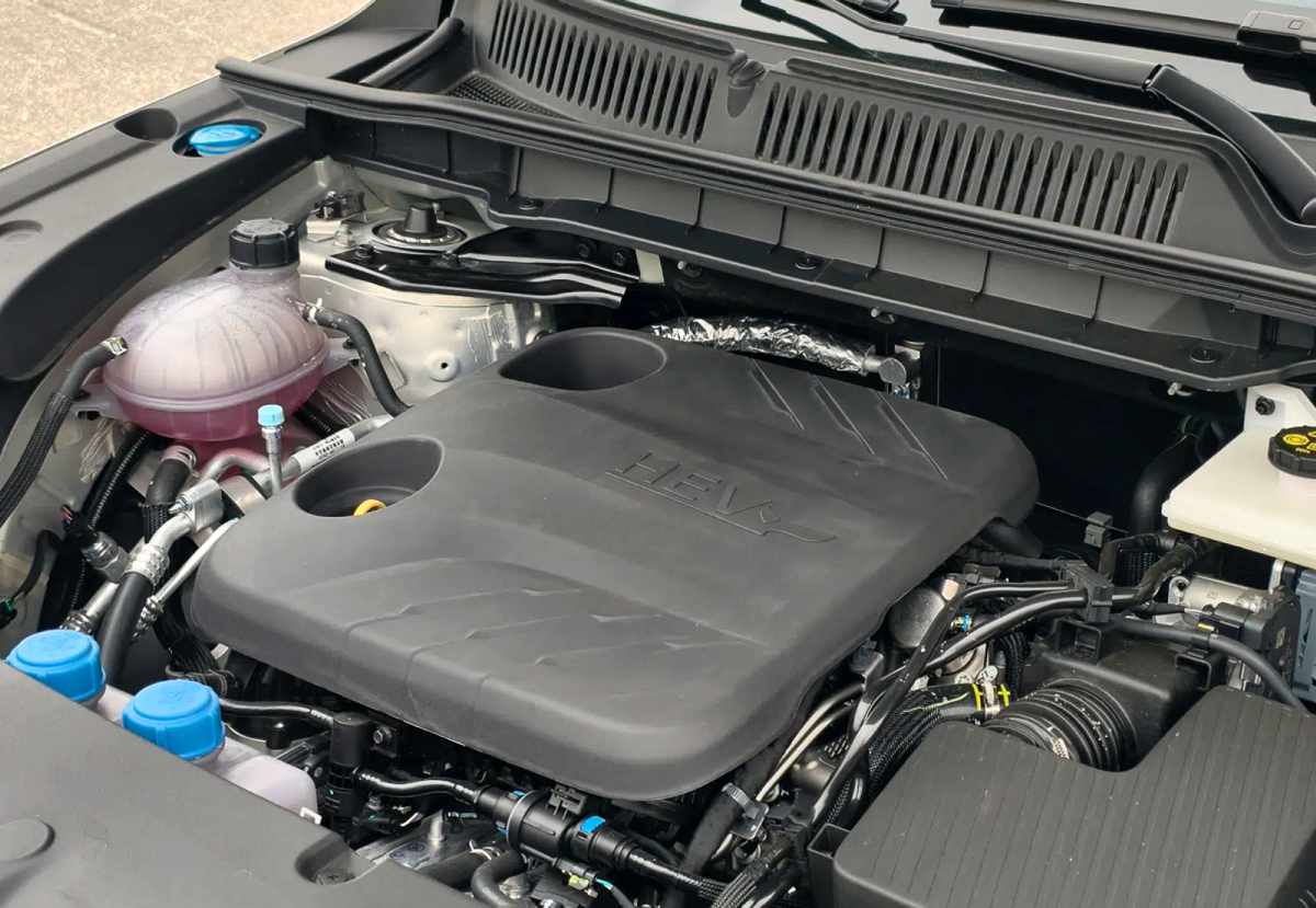 Primer plano detallado del compartimiento mecánico de la Changan CS75 Plus HEV, mostrando la cubierta protectora superior con la inscripción 