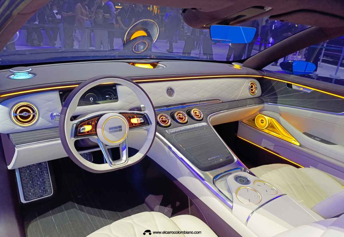 Detalle panorámico del interior del Geely Galaxy Light 2nd Generation, mostrando el volante de base plana, asientos con patrón de rombos, salidas circulares de climatización y la intensa iluminación ambiental amarilla.