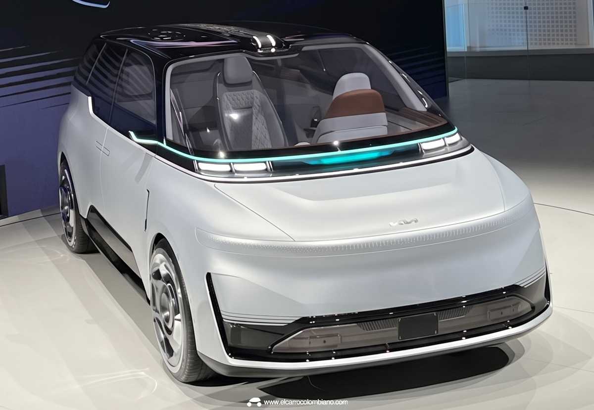 Vista superior a través del techo de cristal hacia el interior del habitáculo del Geely Eva Cab, confirmando la ausencia de volante y pedales, y mostrando asientos enfrentados tapizados en marrón claro y gris con patrón de rombos para una sala de estar sobre ruedas.