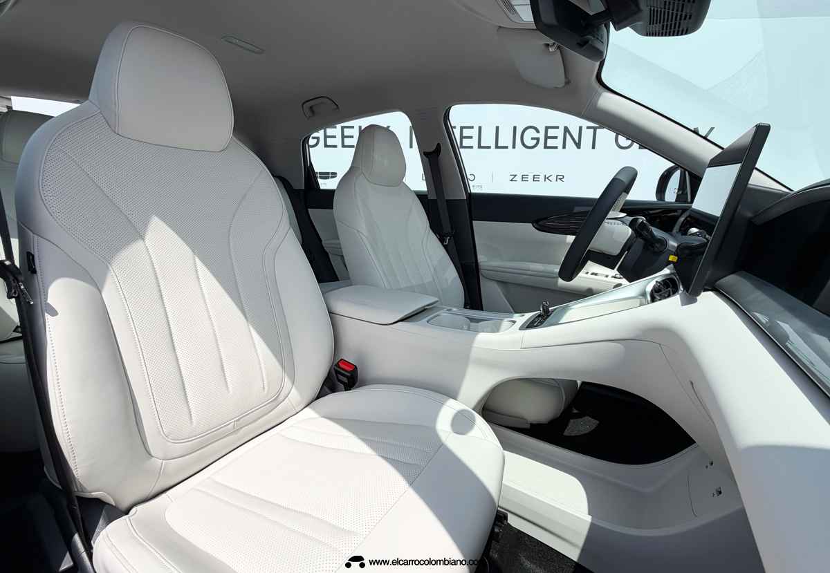 Detalle de las sillas delanteras tapizadas en color claro dentro del Geely EX2, evidenciando los buenos acabados y la consola central alta.