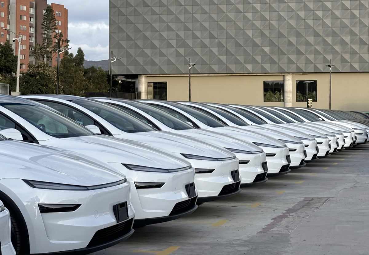 Larga fila de carros eléctricos Tesla Model Y nuevos de color blanco, alineados en el patio de entregas de Tesla en Bogotá, Colombia, representando el auge de matrículas y el histórico récord de ventas alcanzado en abril de 2026. Foto de Instagram @teslaownerscolombia.