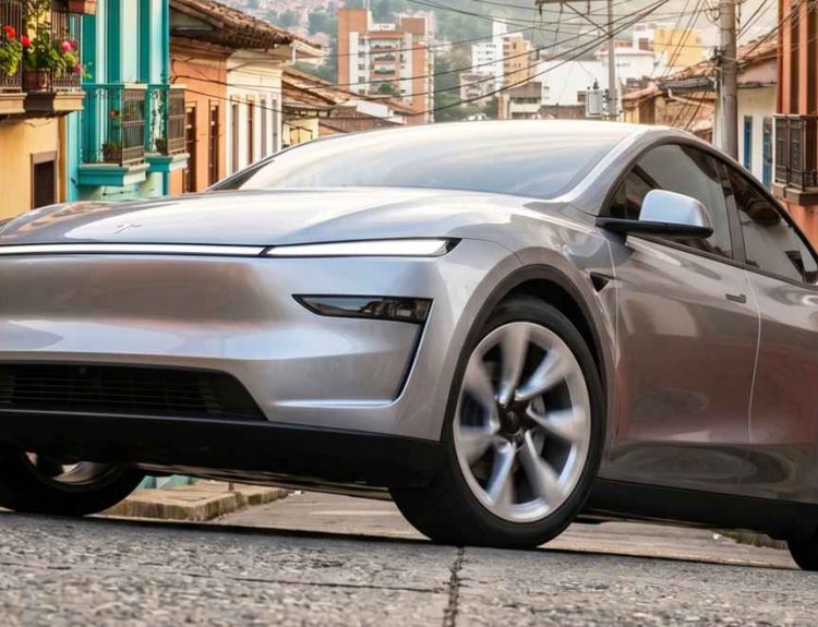Camioneta eléctrica Tesla Model Y de color plateado, estacionada sobre una calle empedrada rodeada de arquitectura tradicional colombiana con fachadas coloridas y balcones. Este modelo se consolidó como el carro más vendido de Colombia durante abril de 2026.