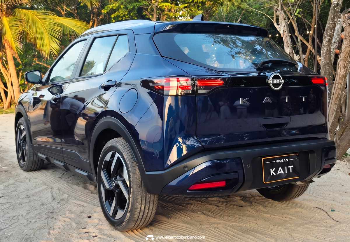 Vista trasera de tres cuartos de la SUV Nissan Kait en azul oscuro sobre arena de playa. Se aprecian las luces traseras LED encendidas, el spoiler, las letras 