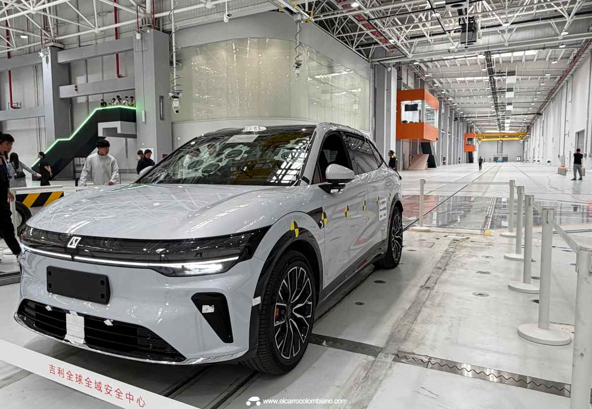 Vista frontal y lateral del SUV eléctrico Zeekr 7X color gris claro, equipado con adhesivos amarillos y negros de calibración, estacionado dentro de las gigantescas instalaciones del Centro de Seguridad de Geely en Ningbo justo antes de iniciar la prueba de choque.