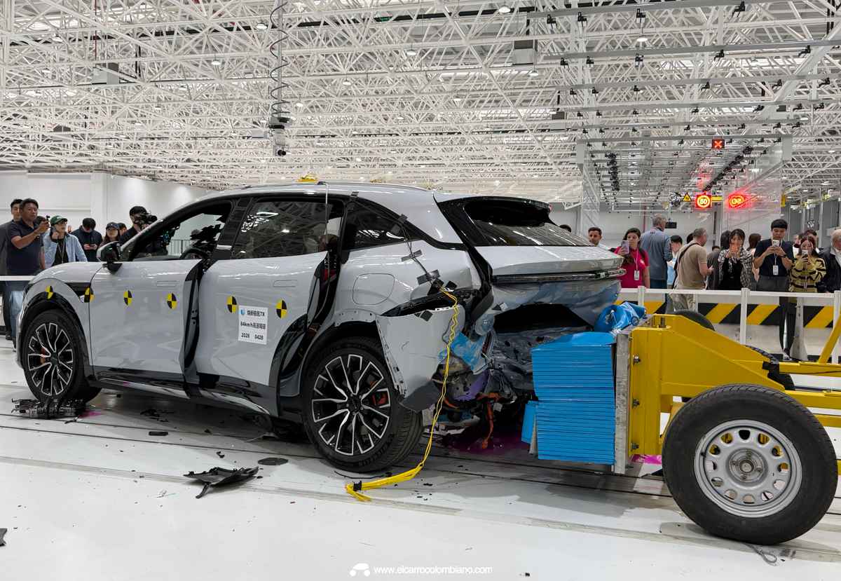 Resultado de la prueba de choque trasero al Zeekr 7X en el laboratorio de Geely. Se observa la parte posterior del vehículo destruida tras el impacto de una plataforma móvil amarilla, mientras la cabina mantiene su integridad estructural y las puertas abiertas evidencian la facilidad de rescate.