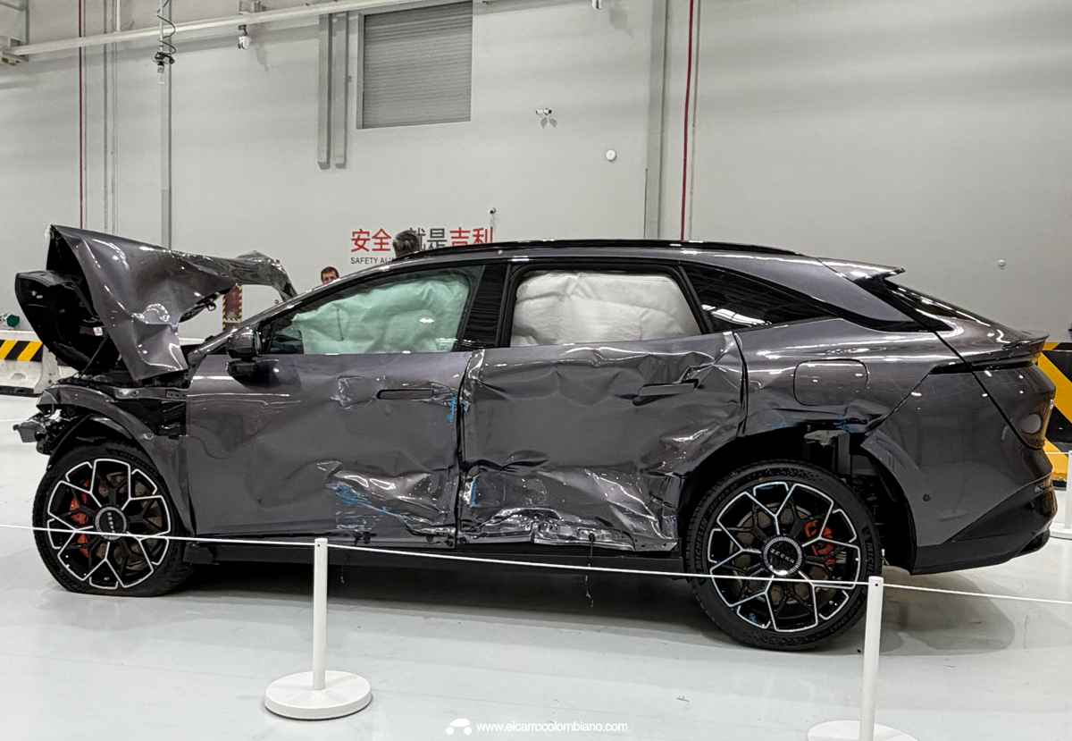 Perfil lateral de una camioneta Zeekr 007 GT fuertemente impactada durante las evaluaciones en China. Destaca el despliegue perfecto de las bolsas de aire de cortina blancas sobre las ventanas, protegiendo el espacio de los maniquíes a pesar de la abolladura general en la carrocería.