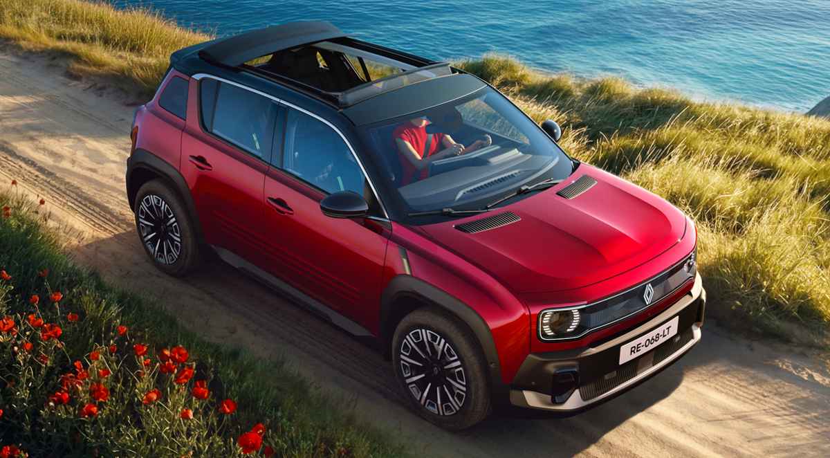 Vista superior en ángulo del nuevo Renault 4 Plein Sud eléctrico color rojo rodando por un camino costero. Destaca su techo de lona oscuro completamente abierto, mostrando el diseño tipo crossover, barras de techo y rines diamantados.