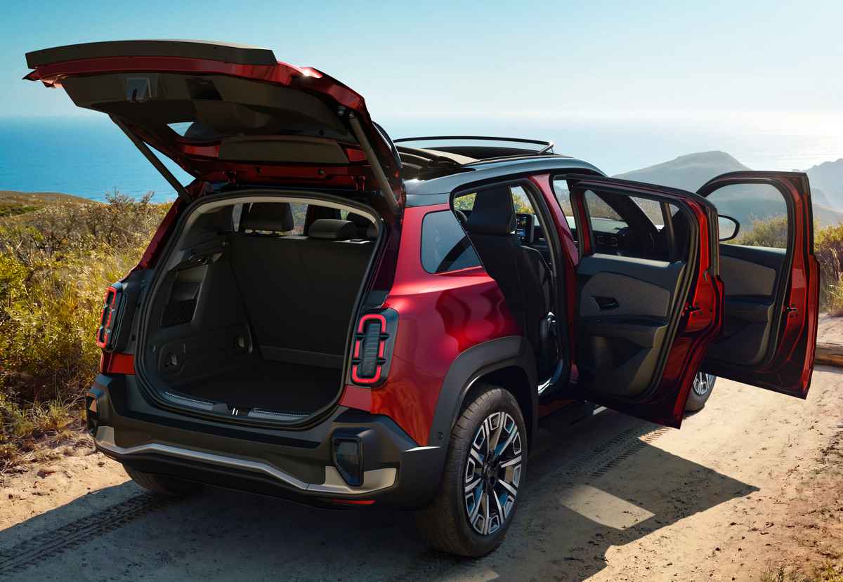 Zona posterior del Renault 4 Plein Sud eléctrico en color rojo con el portón del maletero y las puertas traseras abiertas. Muestra el amplio espacio de carga de 420 litros de capacidad, sus distintivas luces verticales y el parachoques inferior robusto.