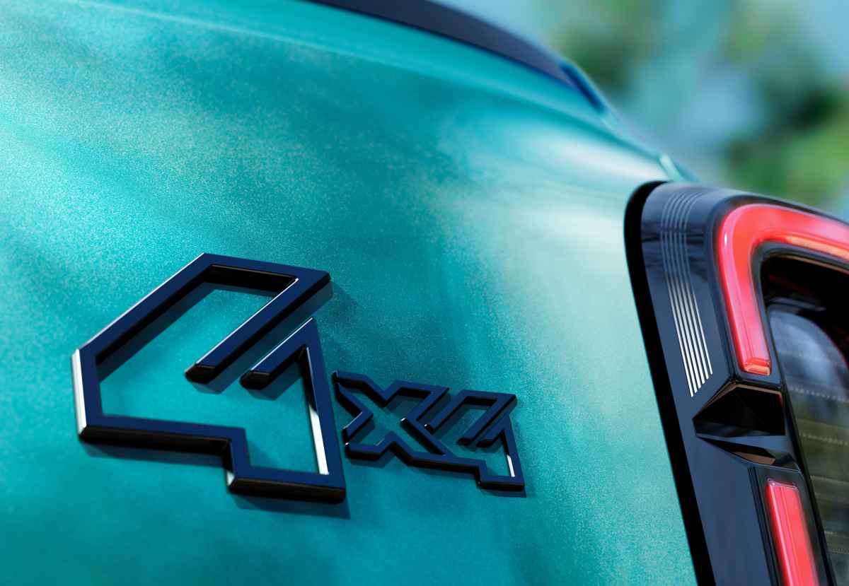 Acercamiento al detalle del emblema 4x4 con efecto tridimensional en relieve de color negro brillante, fijado sobre la pintura verde esmeralda nacarada, justo al lado de la firma lumínica trasera del vehículo Renault 4 JP4x4 Concept.