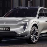 Vista frontal en tres cuartos de la nueva SUV eléctrica Avatr 07L color plata, circulando por una calle urbana y destacando sus estilizadas luces diurnas LED en forma de C.