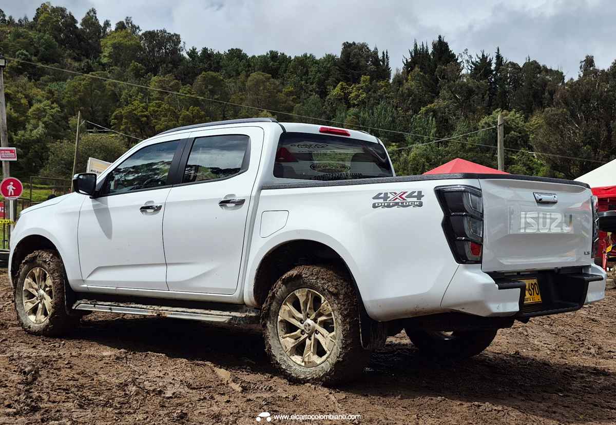Vista posterior en tres cuartos de la Isuzu Pickup 2027 color blanco, mostrando los detalles de su platón, luces traseras y la calcomanía 4x4 en el costado.