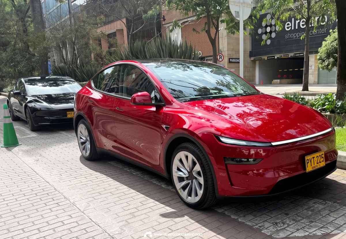 Vista frontal de un Tesla Model Y color rojo parqueado en una calle de Colombia, ilustrando la investigación y medidas de la SIC contra la marca por demoras en sus entregas.