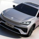 Vista aérea en tres cuartos del nuevo SUV eléctrico MG 4X en color plata, destacando su capó afilado, faros triangulares unidos por una tira LED y su amplio techo panorámico.